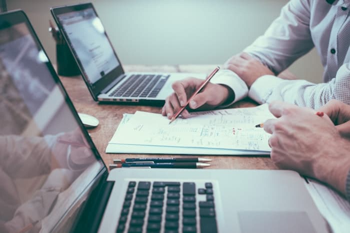 Relatórios com dados e tabelas sobre uma mesa de trabalho